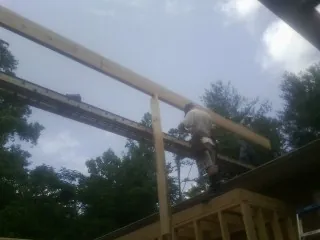 Carpenter setting a ridge beam over a new addition frame — Ice Dam Removal by Roofing Brothers in Morris