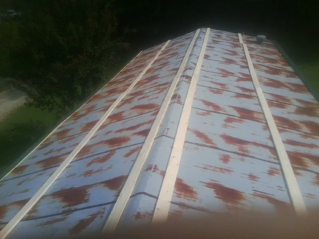 Rusted metal roof panels with new wood purlins before replacement — Storm Damage Roof Repair in Morris by Roofing Brothers